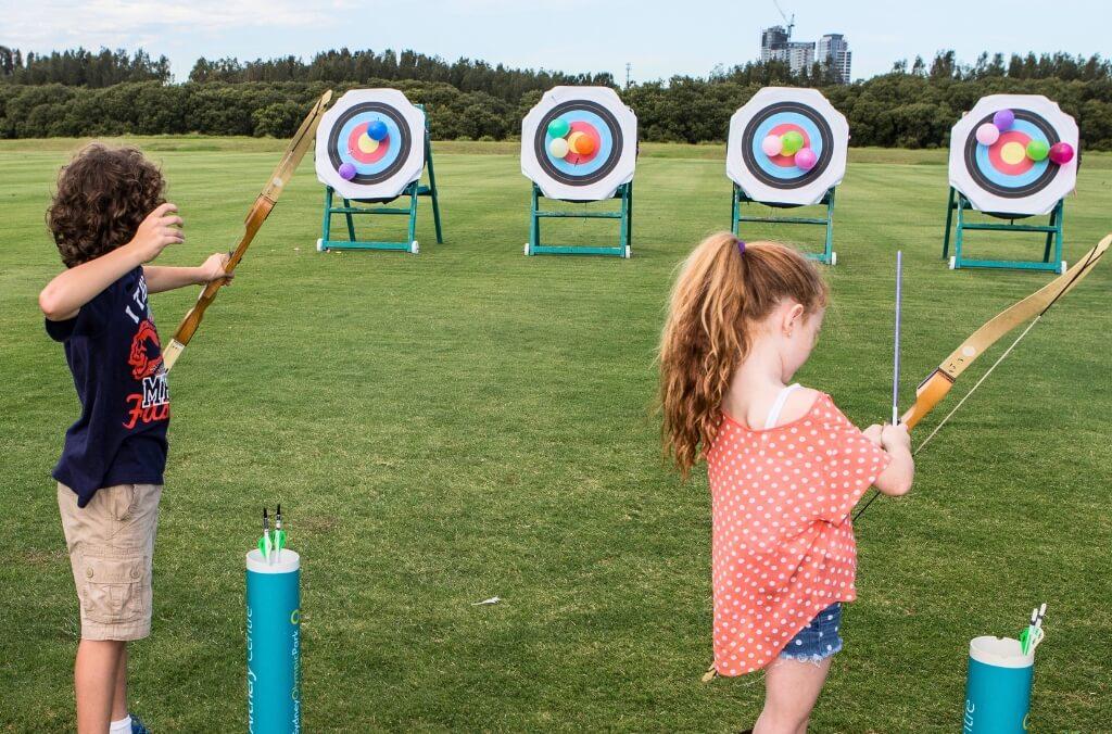 Image of kids lining up with archery bows