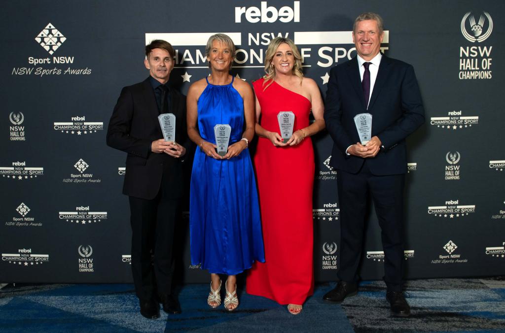 Inductees in front of media wall holding awards, from left Mat Helm (Diving), Layne Beachley AO, Legend (Surfing), Heather Garriock (Football), John Forbes (Sailing)